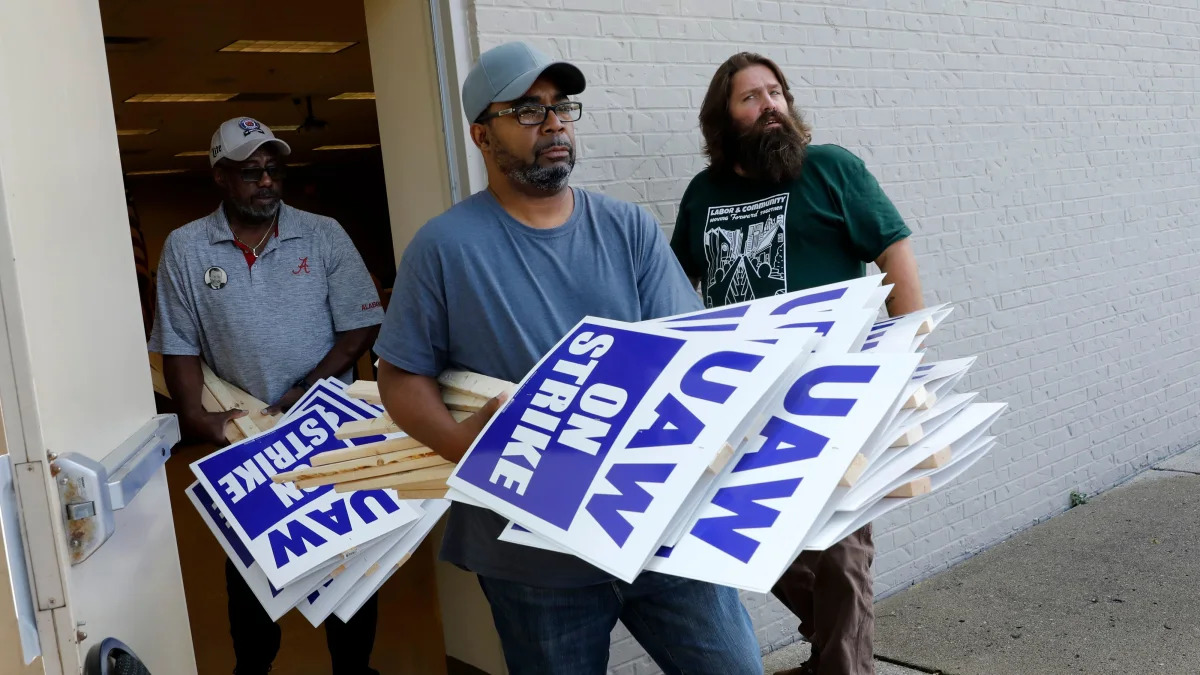 General Motors Co. employee Carl Ellison carries strike signs outside of the United Auto Workers (UAW) Local 163 which represents GMs Romulus Powertrain on September 15, 2019 in Westland, Michigan. - Local UAW leaders from across the nation met Sunday morning in Detroit after the 2015 General Motors collective bargaining agreement expired Saturday night and opted to strike at midnight on Sunday. (Photo by JEFF KOWALSKY / AFP)        (Photo credit should read JEFF KOWALSKY/AFP/Getty Images)