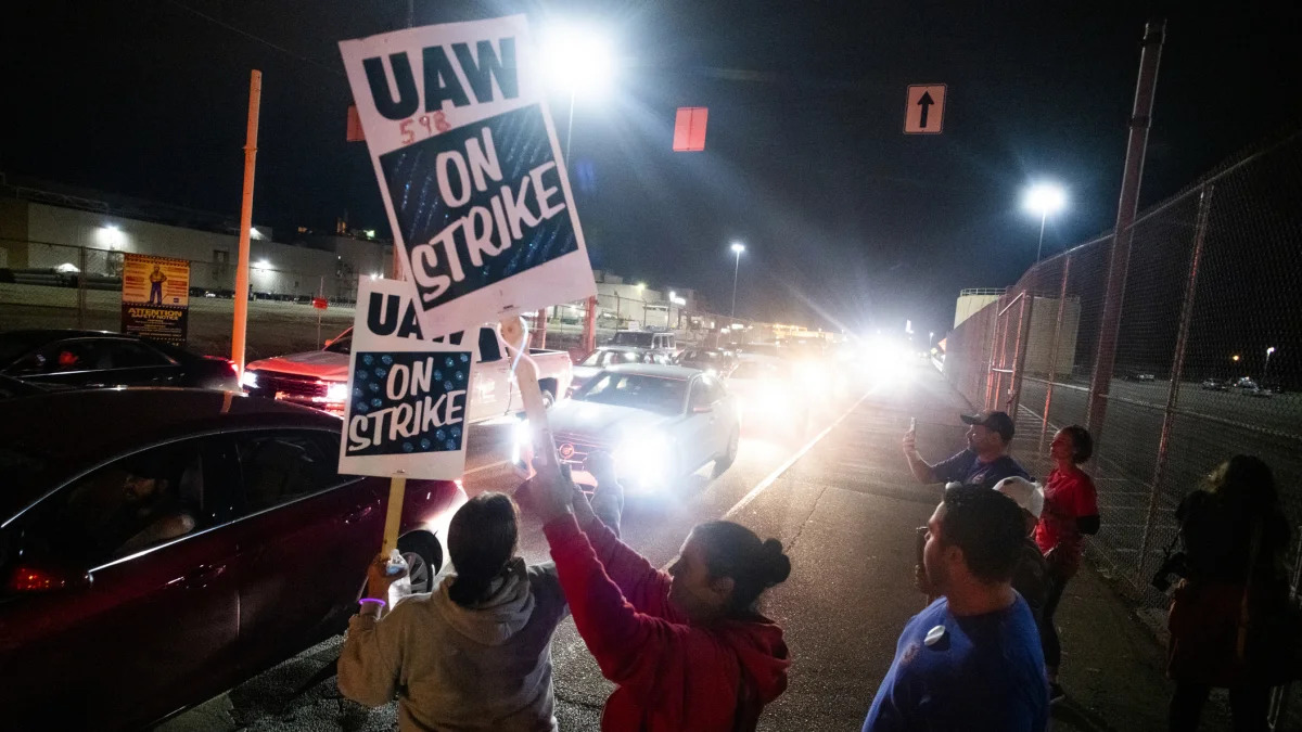 Hundreds of General Motors employees drive off the property, shutting down the Flint Assembly Plant at midnight as part of the national strike on Monday, Sept. 16, 2019 in Flint, Michigan. (Jake May/The Flint Journal via AP)