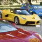 People looking at a Aston Martin One-77 Coupe (2011) in front of a Ferrari LaFerrari (2015), yellow, and a Bugatti Veyron EB 16.4 Coupe (2010), blue, part of some 25 luxury cars owned by Teodoro Obiang, the son of the Equatorial Guinea's President Teodoro Obiang Nguema Mbasogo are pictured before an auction of sales house Bonhams at the Bonmont Abbey Golf & Country Club in Cheserex near Geneva, Switzerland, Sunday, Sept. 29, 2019. A collection of luxury cars from Equatorial Guinea's vice president Teodorin Obiang Nguema confiscated by the Geneva prosecutor's office after a deal ending a money-laundering inquiry, are auctioned off in Switzerland and are estimated to bring in 18.5 million Swiss francs. (Laurent Gillieron/Keystone via AP)