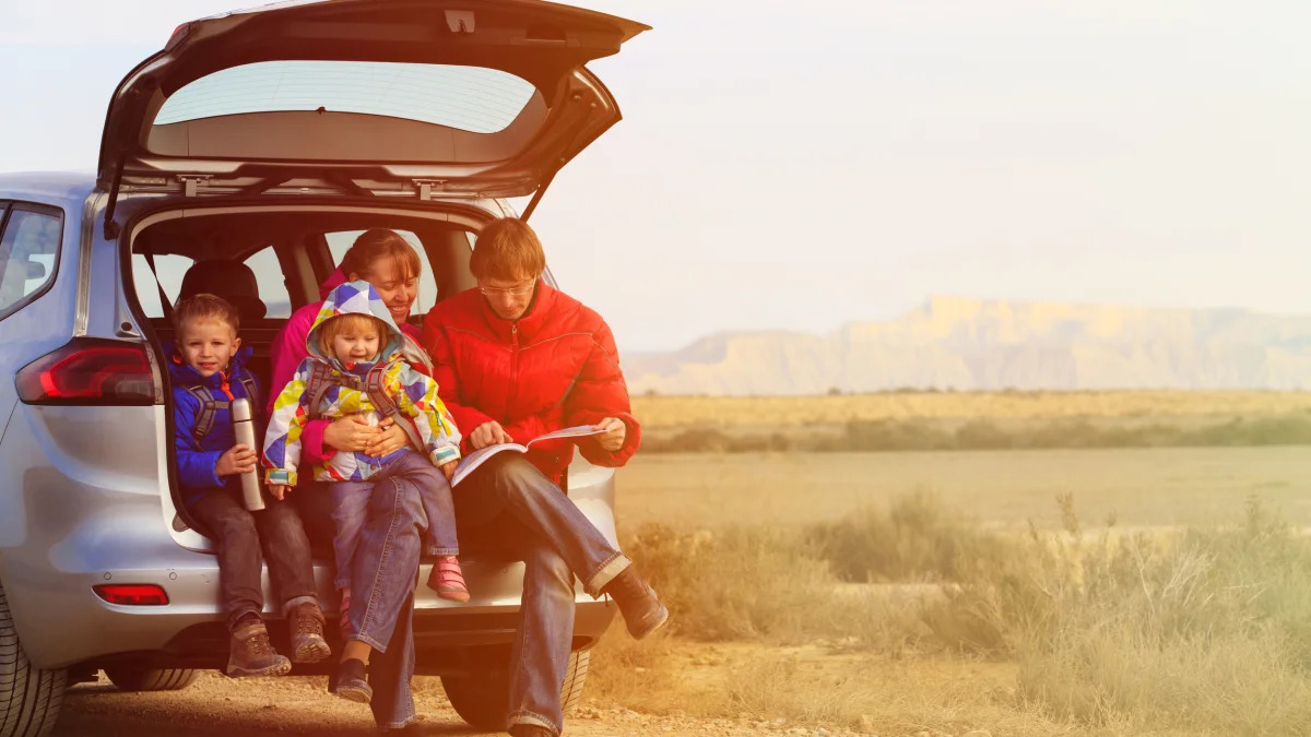family with two kids travel by car in scenic mountains