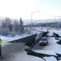 A stranded vehicle lies on a collapsed roadway near the airport after an earthquake in Anchorage