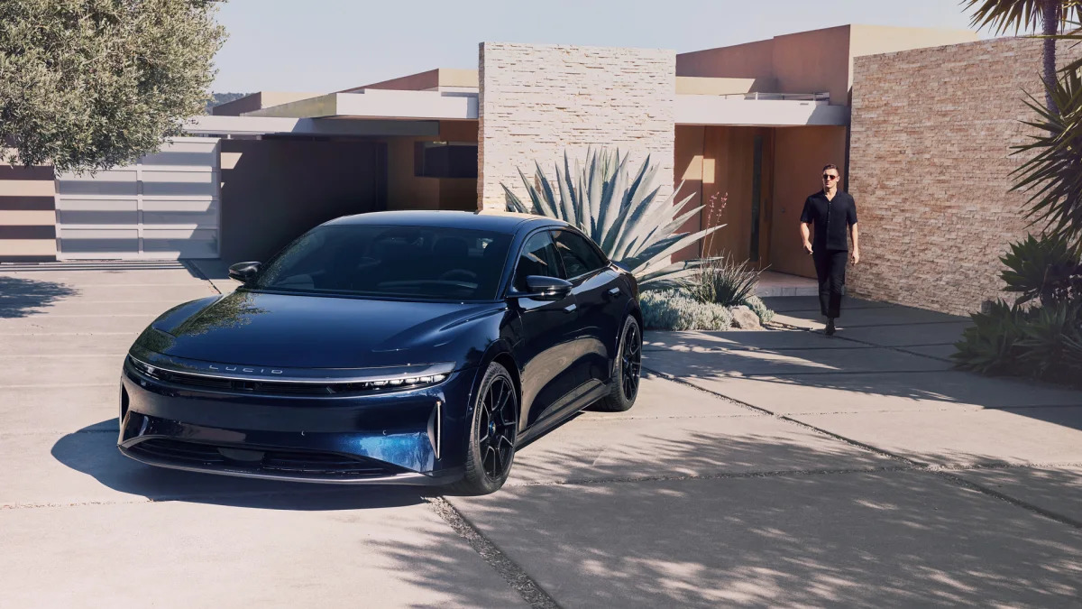 Lucid Air Sapphire lifestyle image with rich tech man dressed in black and his modern house
