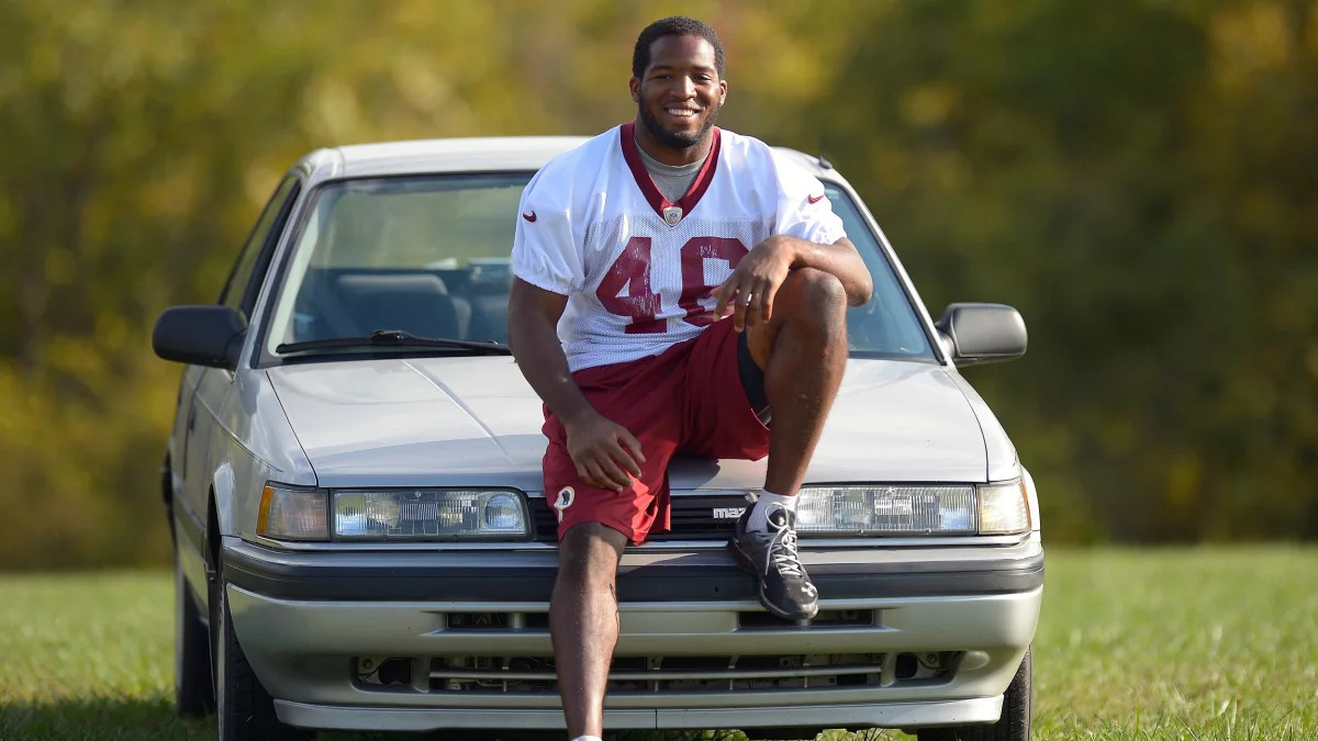 Redskins'  running back Alfred Morris poses with his 1991 Mazda 626
