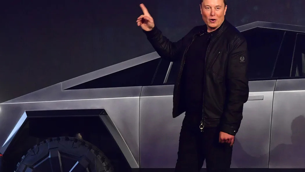 Tesla CEO Elon Musk gestures toward a Cybertruck