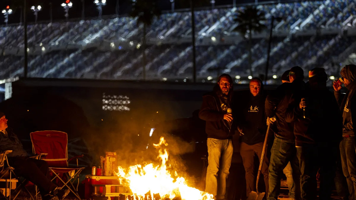 DAYTONA BEACH, FLORIDA - JANUARY 30: Fans stand by a fire during the Rolex 24 at Daytona International Speedway on January 30, 2022 in Daytona Beach, Florida. (Photo by James Gilbert/Getty Images)