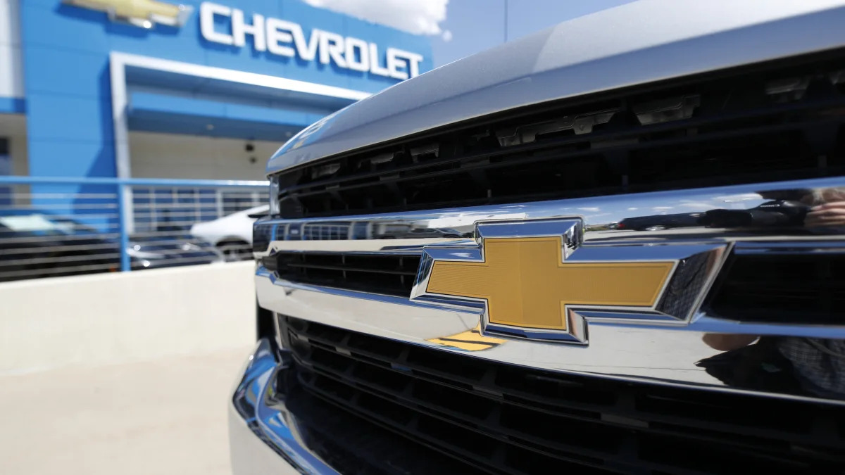 FILE--In this Sunday, July 28, 2019, file photograph, the company logo shines off the grille of an unsold 2019 Chevrolet Silverado pickup truck at a dealership in Englewood, Littleton, Colo. (AP Photo/David Zalubowski, File)