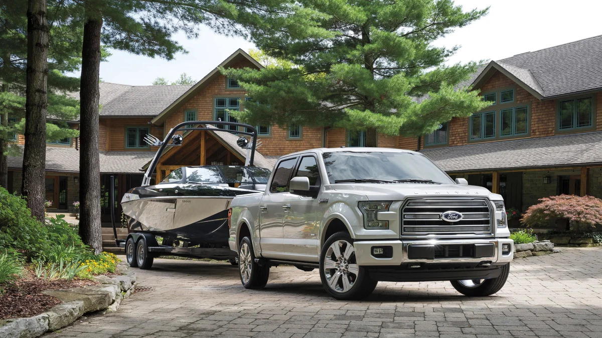The 2016 Ford F-150 Limited towing a boat, front three-quarter view.