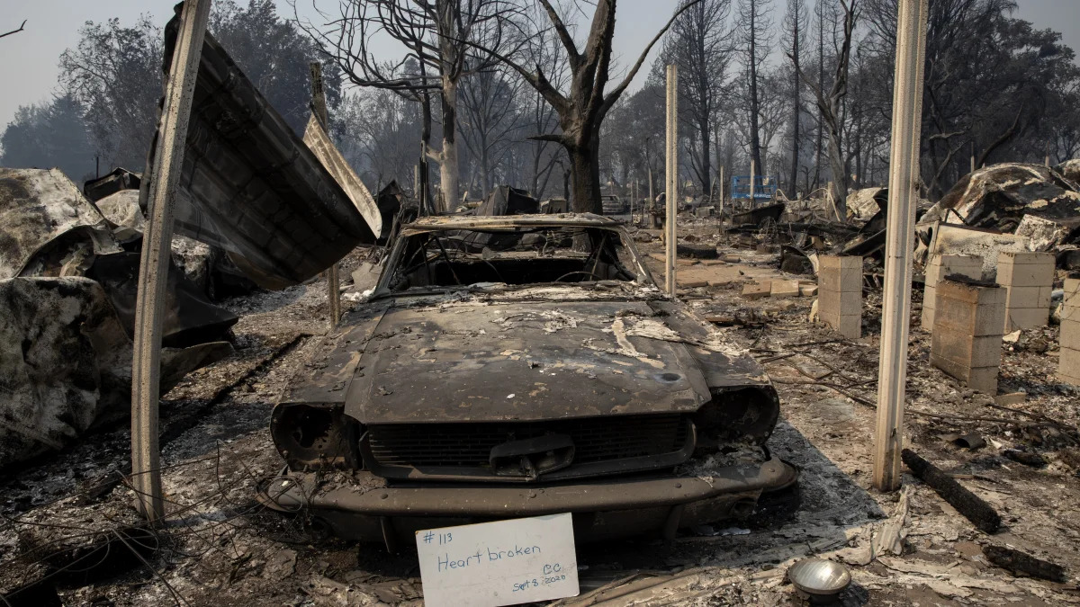 A sign that reads "Heart broken" is displayed in front of a destroyed vehicle at Coleman Creek Estates mobile home park in Phoenix, Ore., Thursday, Sept. 10, 2020. The area was destroyed when a wildfire swept through on Tuesday, Sept. 8. (AP Photo/Paula Bronstein)