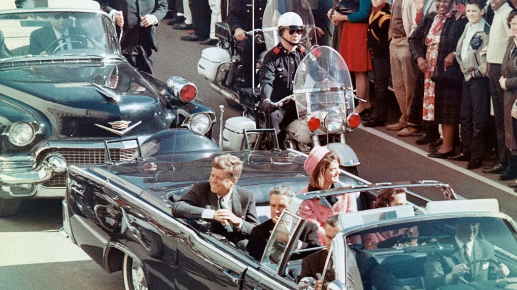 John F. Kennedy rides in the presidential limousine in Dallas, Texas, in 1963