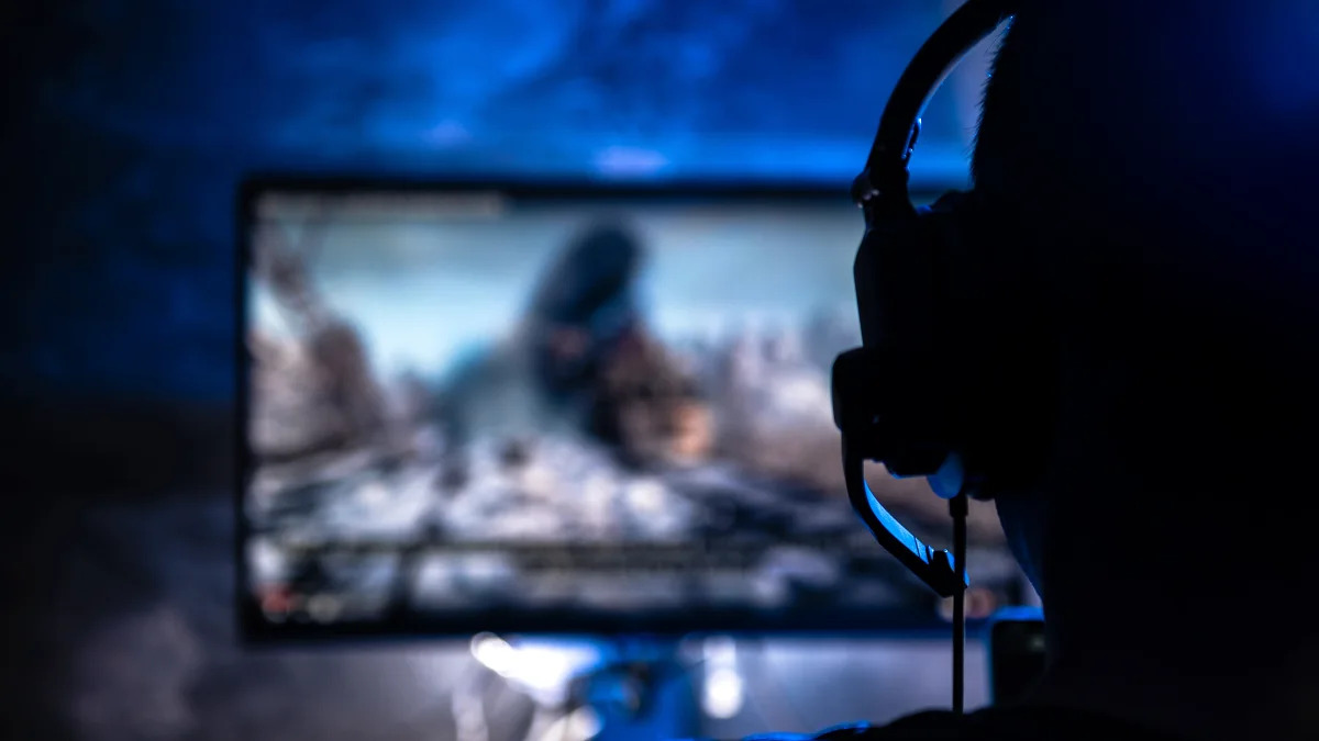 Men wearing headphones playing video games late at night