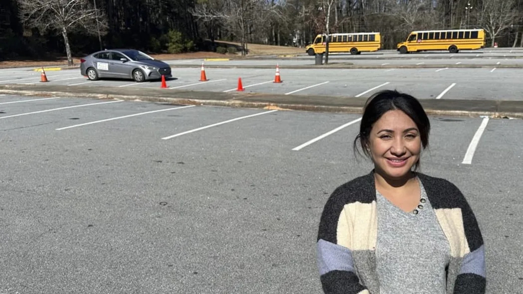 Nancy Gobran, propietaria e instructora de la Escuela de Conducción de Seguridad, sonriendo frente a un conductor