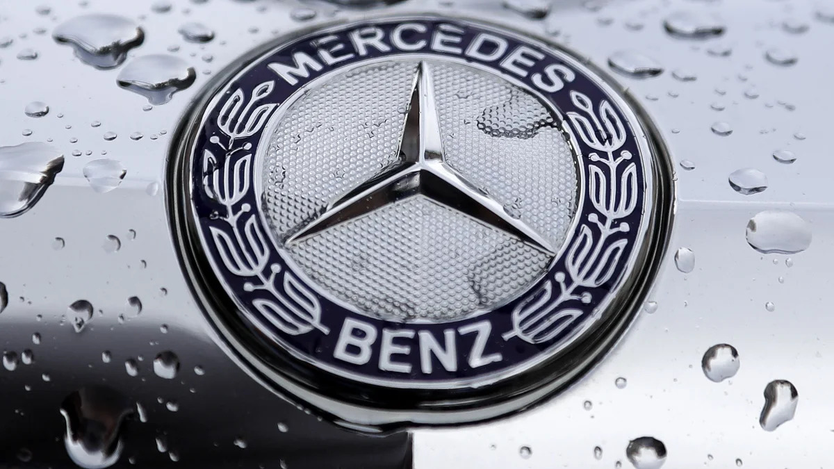 The logo of German car manufacturer Mercedes-Benz is rain covered at a car in Munich, Germany, Friday, July 28, 2017. (AP Photo/Matthias Schrader)