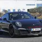 Spy shot of the next-generation 992-model Porsche 911 thought to hide a hybrid powertrain, front three-quarter.