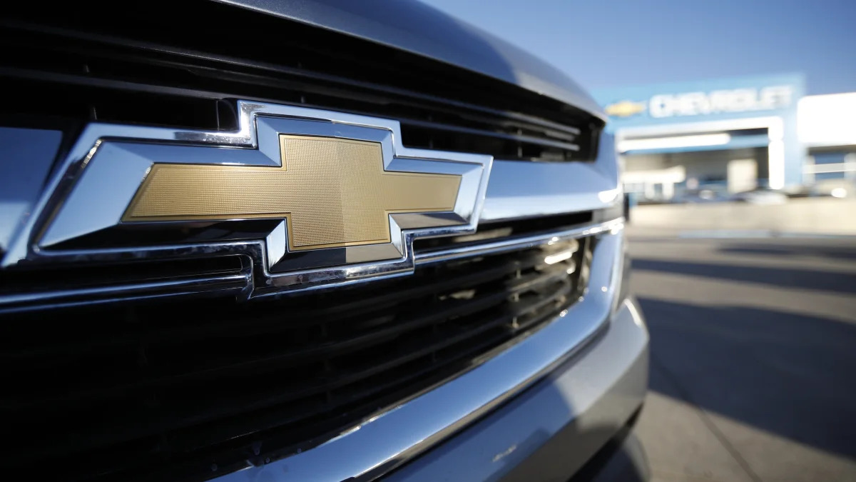 In this Sunday, Feb. 3, 2019, file photograph, the corporate bowtie logo gleams off the grille of an unsold 2019 Colorado pickup as it sits at a Chevrolet dealership in Littleton, Colo. (AP Photo/David Zalubowski)