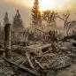 A vintage car rests among debris as the Camp Fire tears through Paradise, Calif., on Thursday, Nov. 8, 2018. Tens of thousands of people fled a fast-moving wildfire Thursday in Northern California, some clutching babies and pets as they abandoned vehicles and struck out on foot ahead of the flames that forced the evacuation of an entire town. (AP Photo/Noah Berger)
