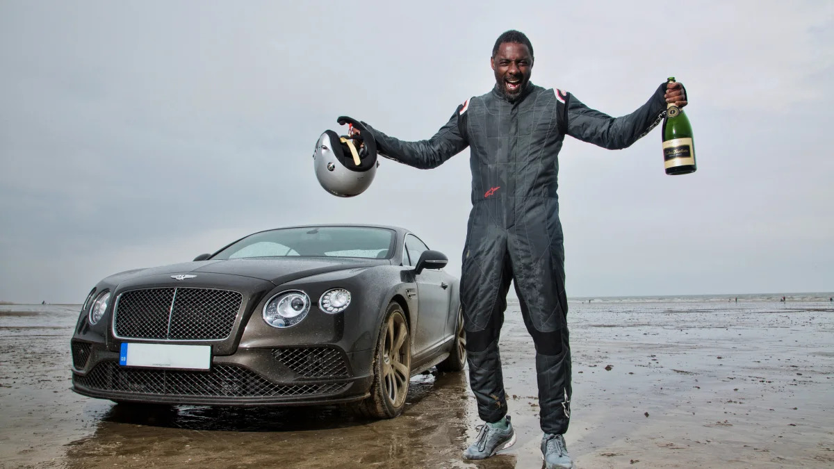 Idris Elba celebrates with the Bentley Continental GT Speed in Wales