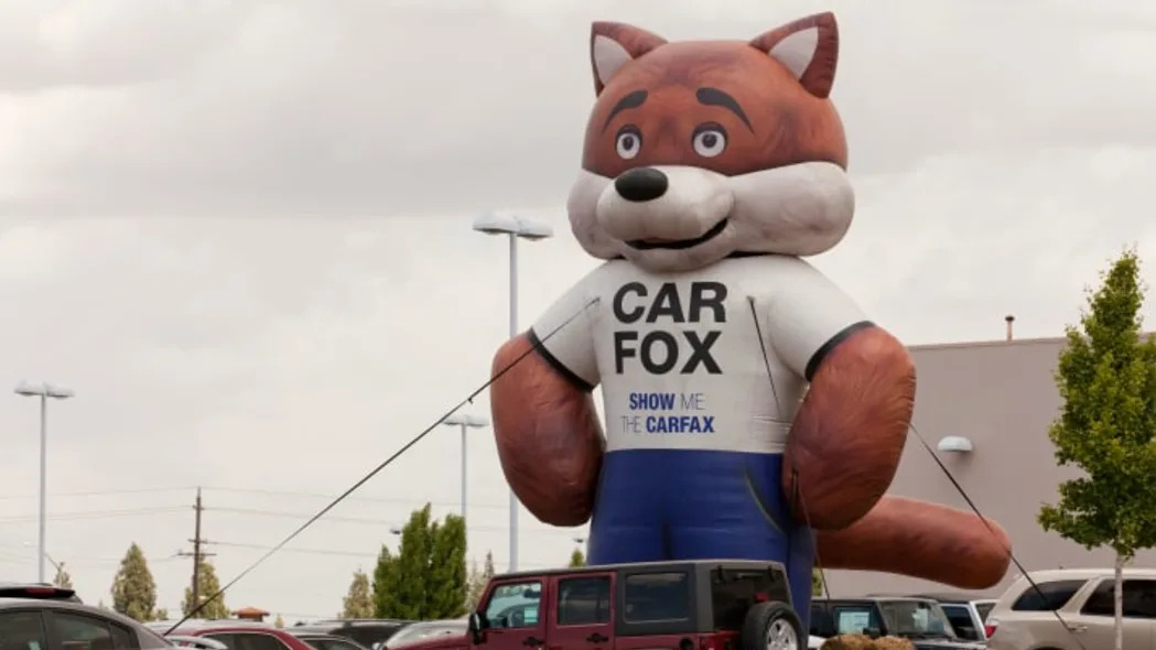 Carfax Carfox balloon display at a used car sales lot - California USA