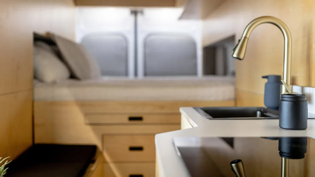 Inside Grounded's camper van with a bed, sink