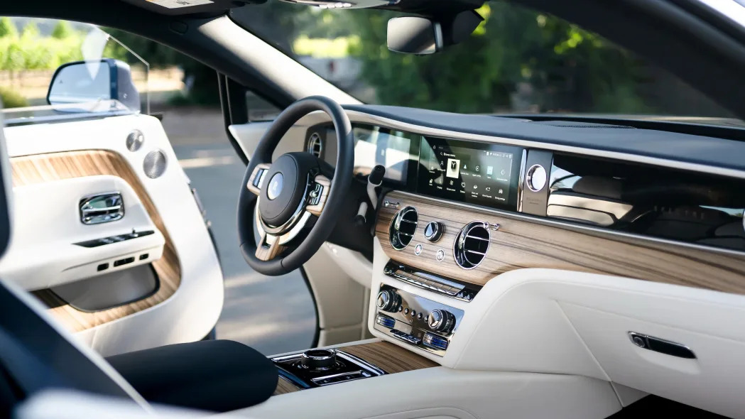 The wood and white-leather interior of a Rolls-Royce Spectre electric car.