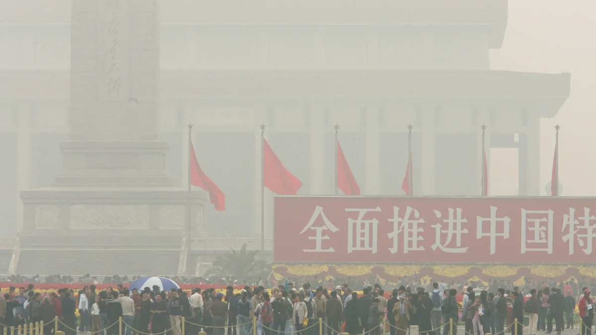 CHINA SMOG CRACKDOWN (** FILE ** Visitors walk through haze hanging over Beijing's Tiananmen Square in this Oct. 10, 2004 file photo. Shougang, a major Chinese steelmaker, has been told to cut output 