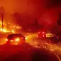 Embers fly across a roadway as the Kincade Fire burns through the Jimtown community of Sonoma County, Calif., Oct. 24, 2019. (AP Photo/Noah Berger)