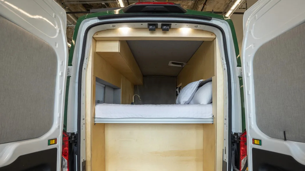 Inside Grounded's camper van with a bed