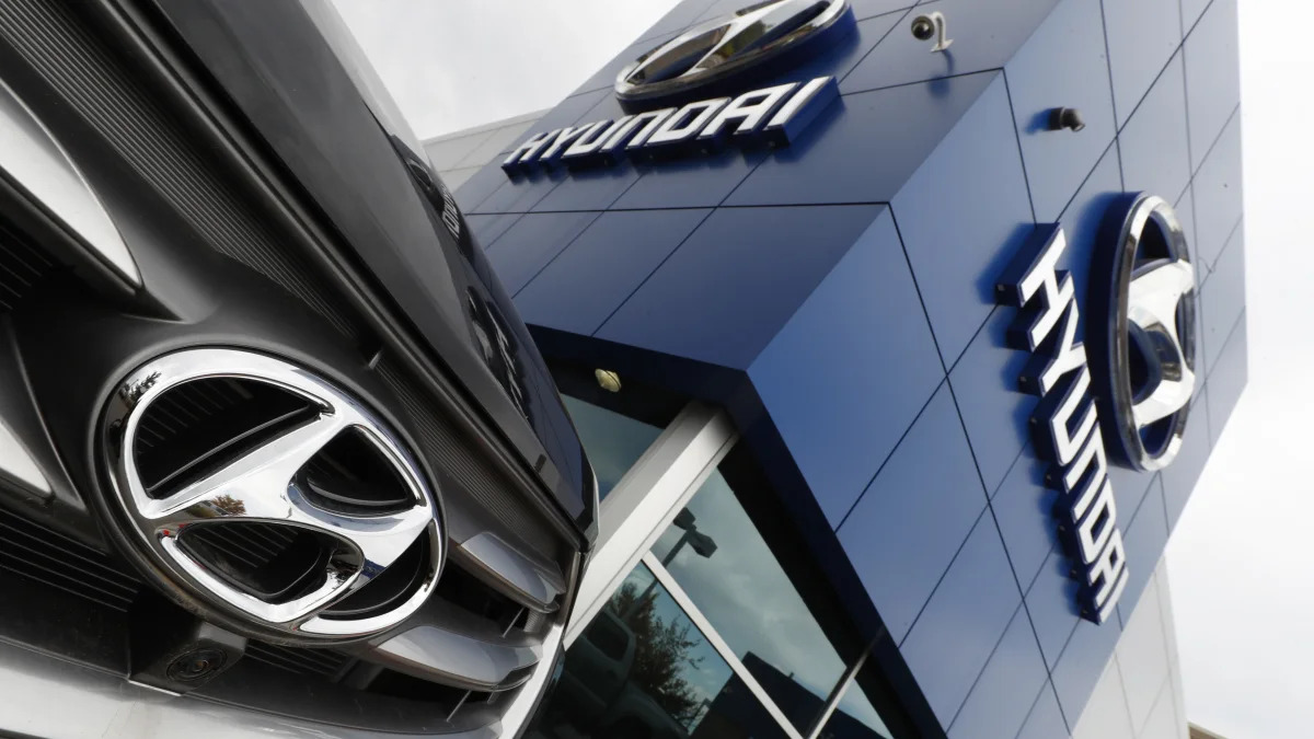 In this Friday, Oct. 6, 2017, the company logo shines off the grille of an unsold 2018 Santa Fe sports utility vehicle outside a Hyundai dealership in the south Denver suburb of Littleton, Colo. (AP Photo/David Zalubowski)