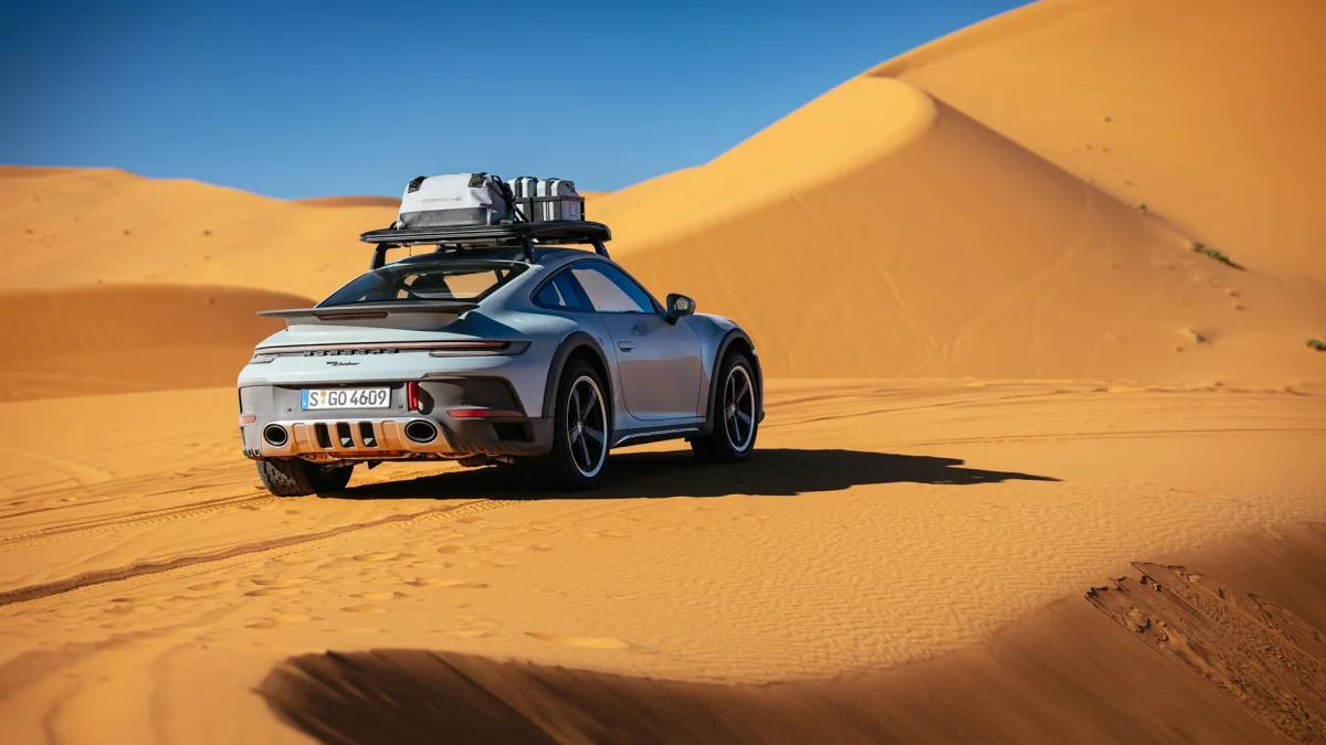 2023 Porsche 911 Dakar in Shade Green rear three quarter on dune