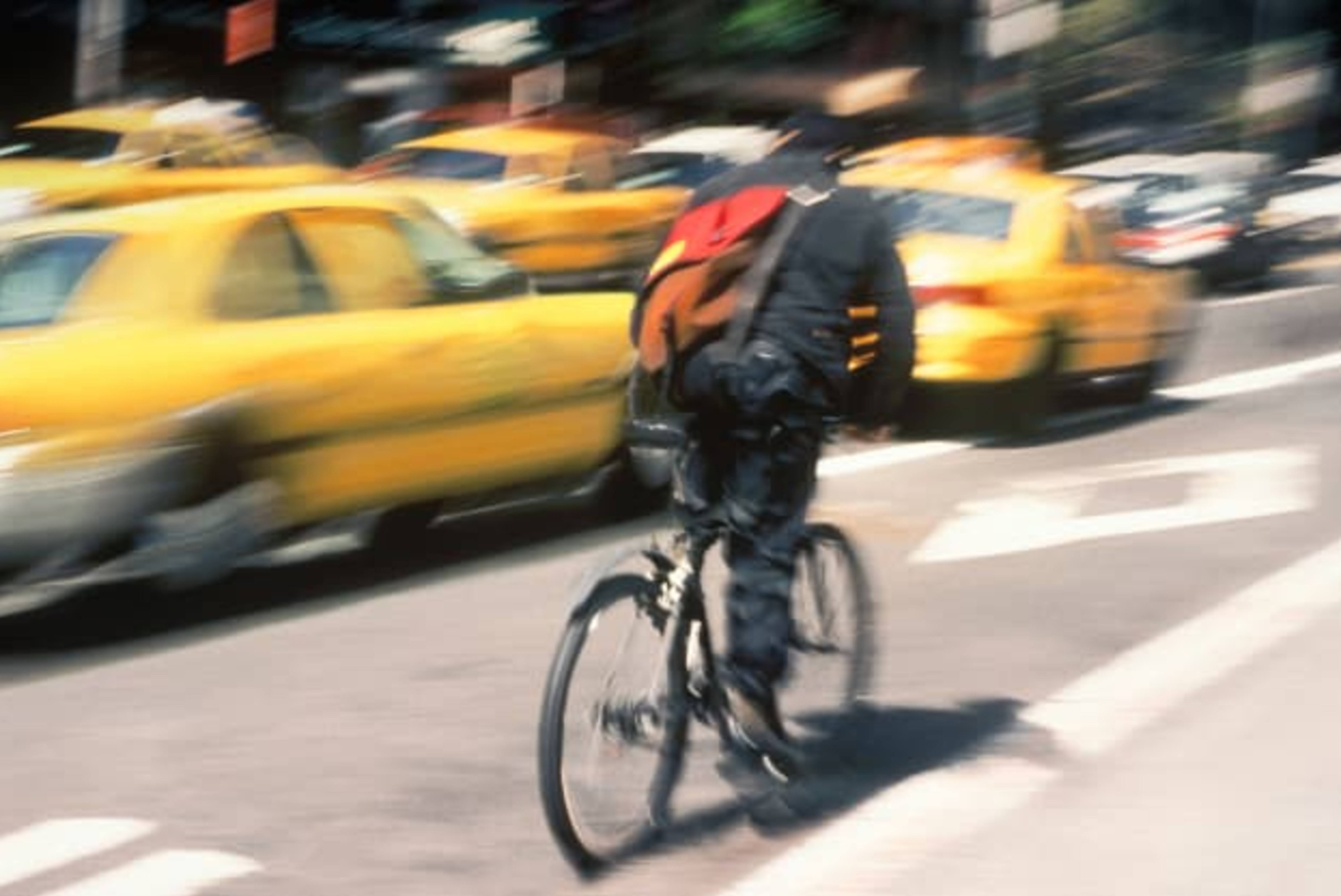 USA New York Bike Messenger Making Delivery Through Traffic on a City Street
