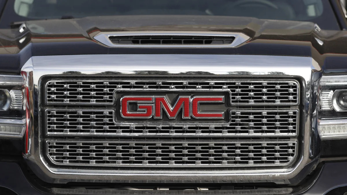 In this Sunday, Nov. 10, 2019, photograph, the company logo shines off the grille of an unsold 2020 Sierra pickup truck at a GMC dealership in Littleton, Colo. (AP Photo/David Zalubowski)