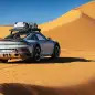 2023 Porsche 911 Dakar in Shade Green rear three quarter on dune