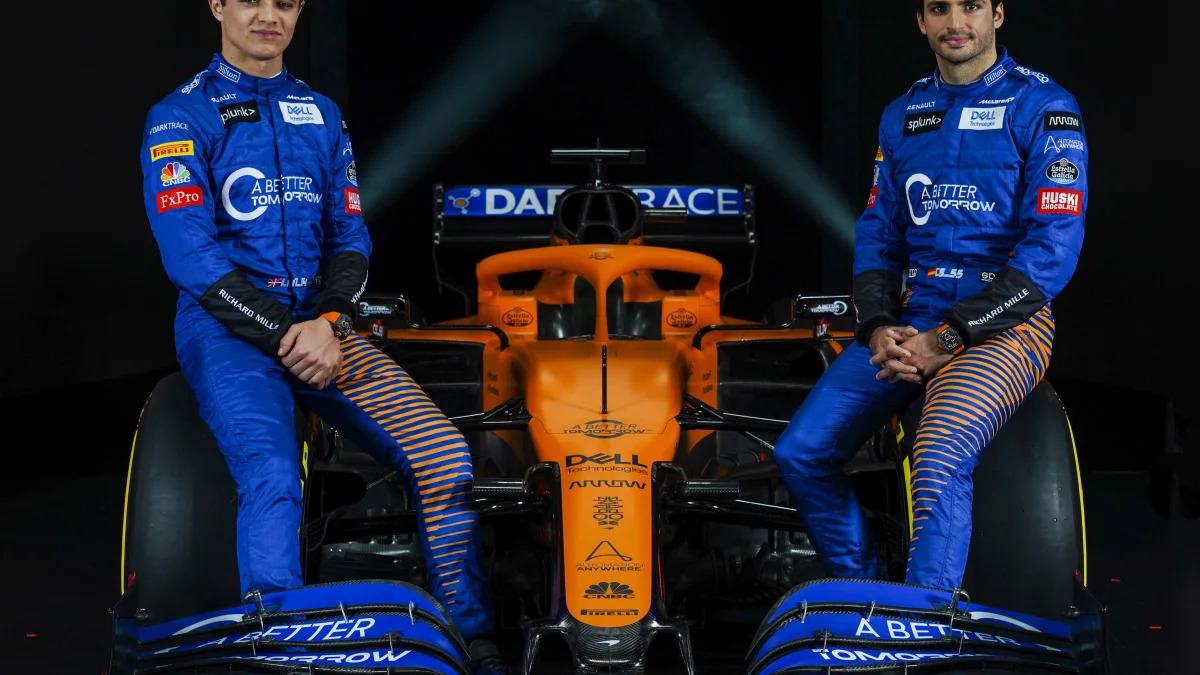 IMAGE DISTRIBUTED FOR MCLAREN - McLaren drivers Lando Norris, left, and Carlos Sainz, sit either side of McLaren's new 2020 Formula 1 car, the MCL35, unveiled at the McLaren Technology Centre on Thursday, Feb. 13, 2020, in Woking, United Kingdom. Press release and full launch media assets available to download at http://www.apmultimedianewsroom.com/multimedia-newsroom/mclaren-reveals-the-mcl35-to-the-world. (Zak Mauger/McLaren via AP Images)