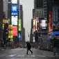 A man walks through a nearly empty Times Square, which is usually very crowded on a weekday morning, Monday, March 23, 2020 in New York. Gov. Andrew Cuomo has ordered most New Yorkers to stay home from work to slow the coronavirus pandemic. (AP Photo/Mark Lennihan)