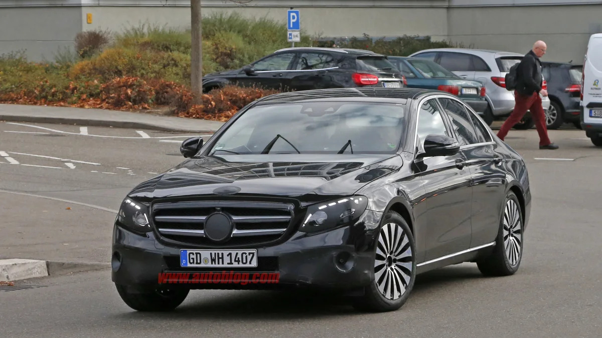 The 2017 Mercedes-Benz E-Class, front three-quarter view with camouflage.