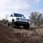 2023 Land Rover Defender V8 off road uphill with rocks